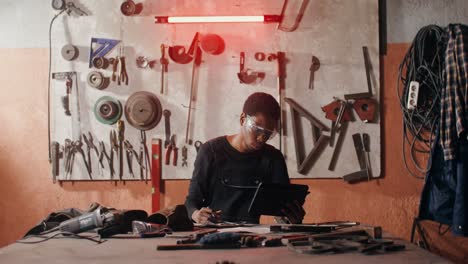 hombre usando una tableta en un taller de metal