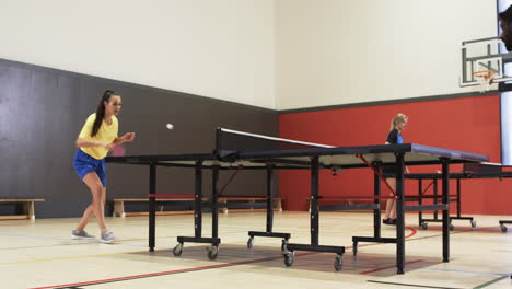 playing table tennis, woman and man competing in indoor sports facility