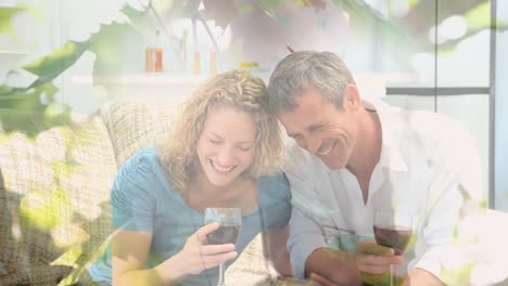 animation of lights over happy caucasian couple drinking wine at home