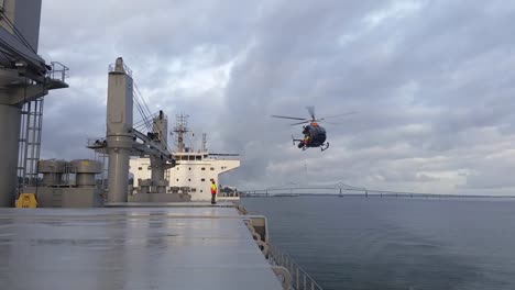 helicopter getting close to the deck, pilot disembarking operation at open sea