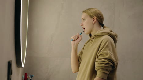 woman brushing her teeth in a bathroom