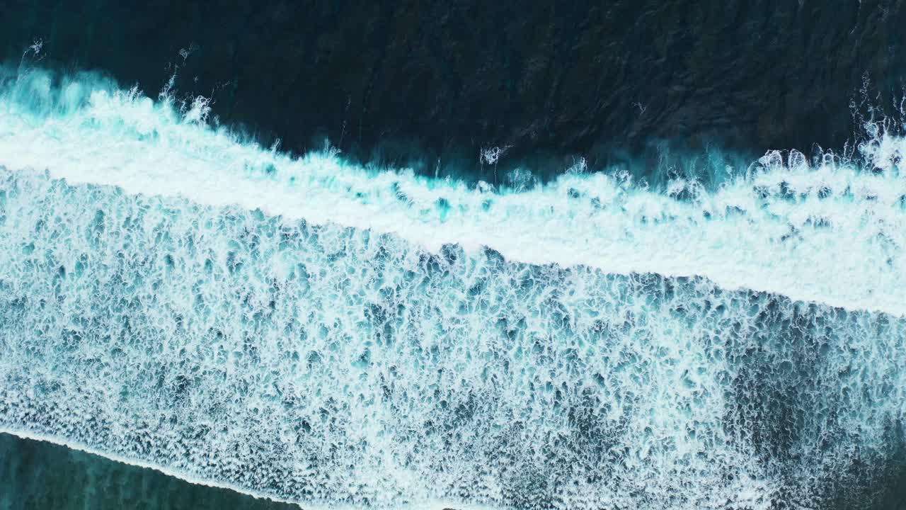 Waves of turbulent sea flood the coast making white foam