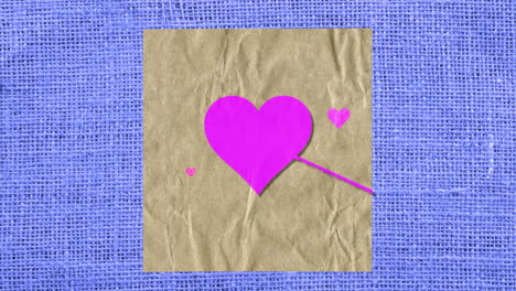 pink hearts with arrow on paper and blue textile