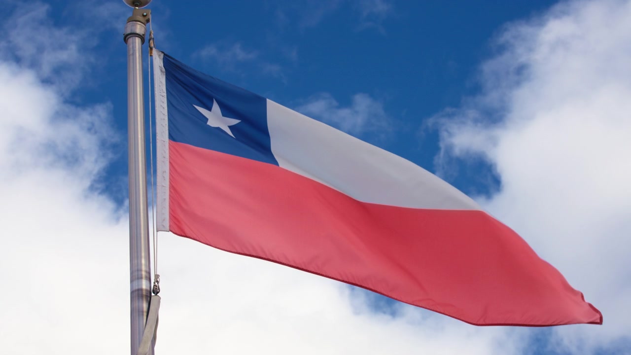 Chilenische Flagge weht im Wind vor blauem Himmel.