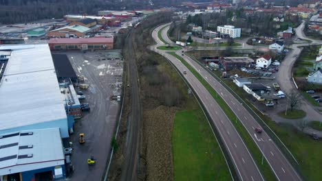 Industrial-Warehouse-and-Highway-in-Fagersta-Sweden,-Aerial-Forward