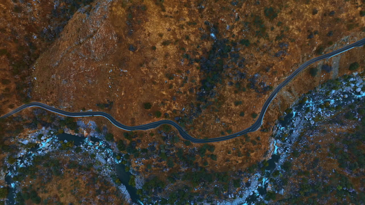 Wavy road in the mountainous area. Speed highway in dangerous place along the mountain river. Top view.