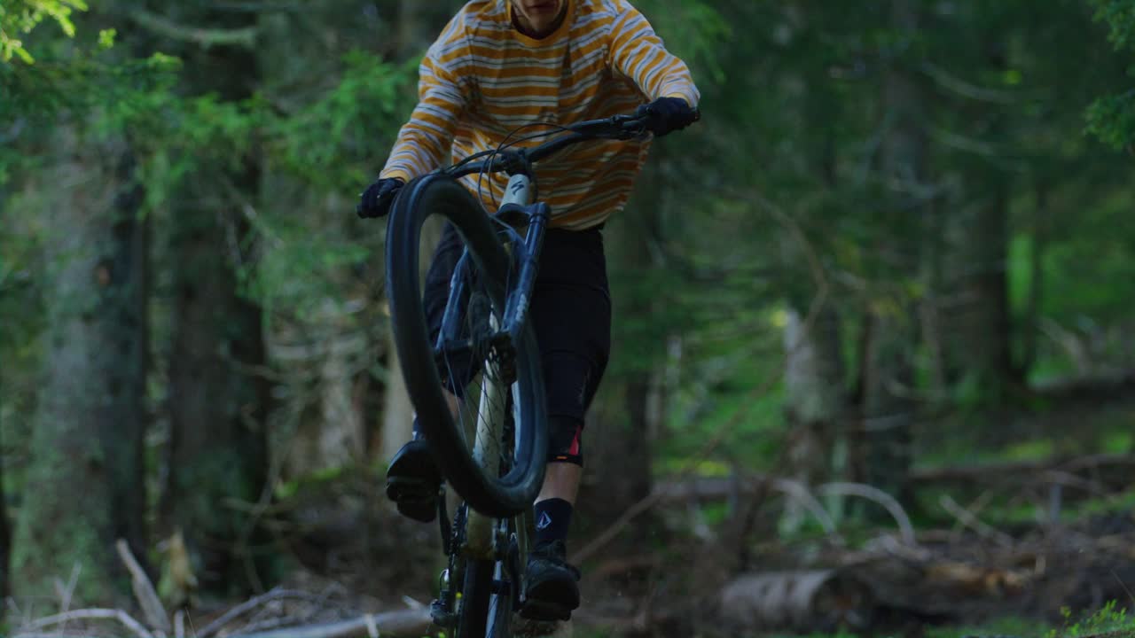 un ciclista de montaña monta solo en su rueda trasera