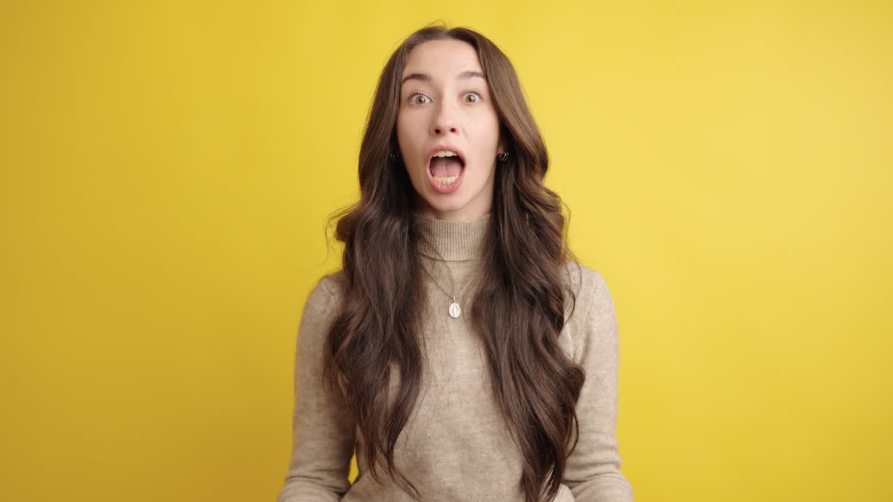 Expressive woman showing surprise and curiosity on yellow background