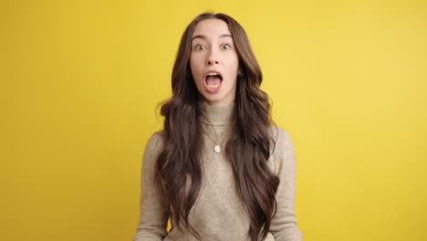 expressive woman showing surprise and curiosity on yellow background