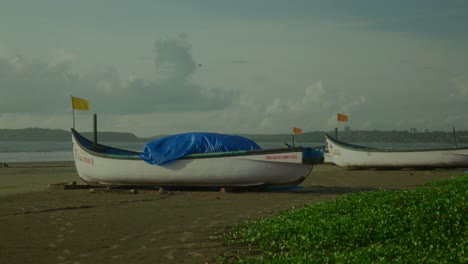 a picturesque shot captures traditional indian fishing boats elegantly lined up along the sun-kissed beach, showcasing their vibrant colors and distinctive designs