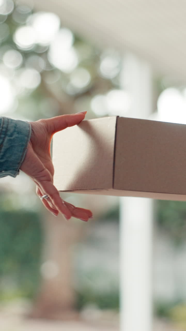 Close-Up of Hand Receiving Cardboard Package from Delivery Person