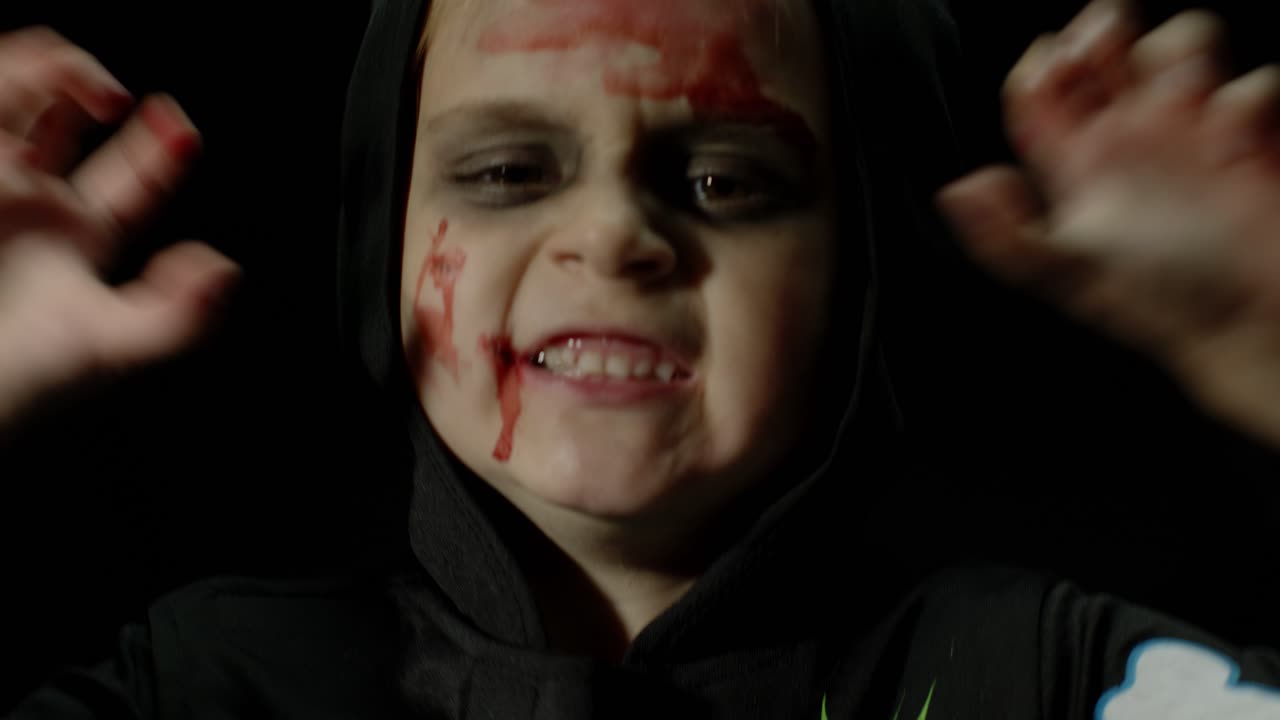 할로윈, 얼굴에 피 메이크업이 있는 화가 난 소녀, 무서운 골격으로 옷을 입은 아이, 포즈를 취하고, 얼굴을 짓고