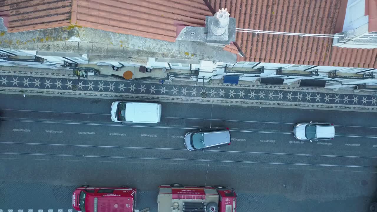 In the early morning hours before the World Youth Days, an aerial view captures the charm of Lisbon's typical streets, adorned with passing cars and the promise of a vibrant day ahead