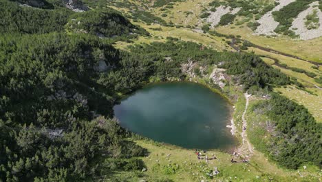 gente en el parque nacional de pirin lago de montaña en bulgaria - aéreo 4k circular