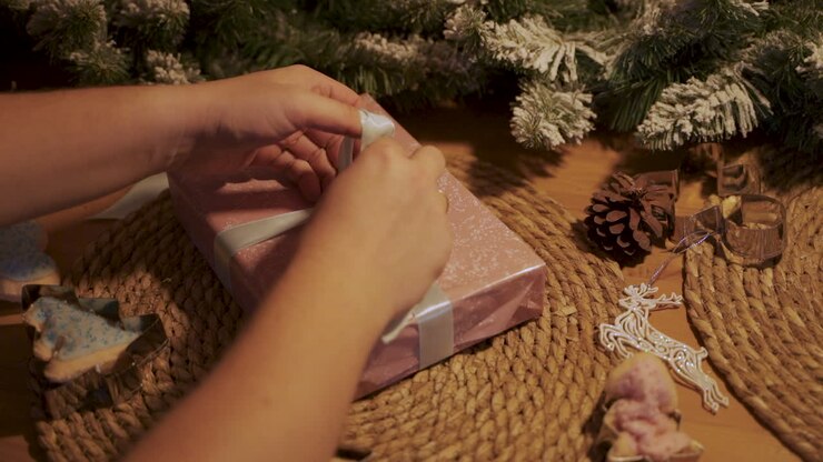 Tangan Mengikat Pita Hadiah Natal