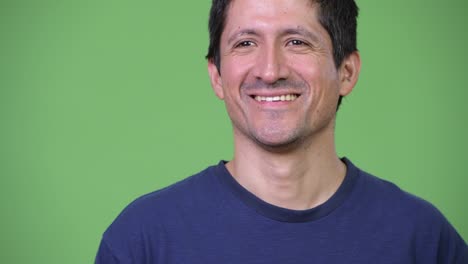 happy hispanic man thinking against green background