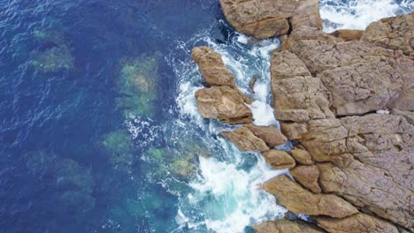 drone shot of waves hitting the cliff