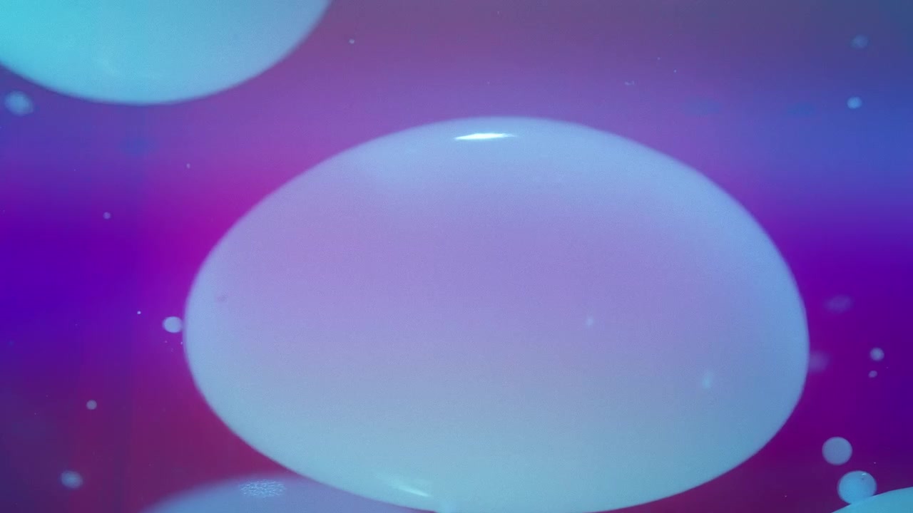 Laavakuplat virtaavat nesteessä purppuranvärisellä liukuvärjätyllä taustalla