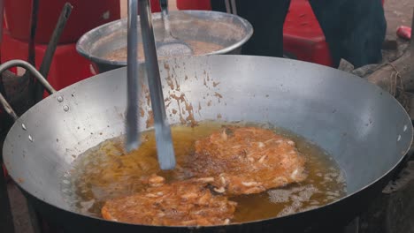 medium shot of shrimp cakes frying at the side of the road