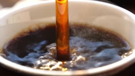 a captivating close-up of rich black coffee in a cup, transitioning with a splash of cream that creates beautiful swirls and bubbles, showcasing liquid dynamics