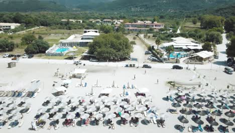 Sonniger-Tag-In-Griechenland,-Der-über-Wasser-In-Richtung-Strand-Fliegt,-Antenne