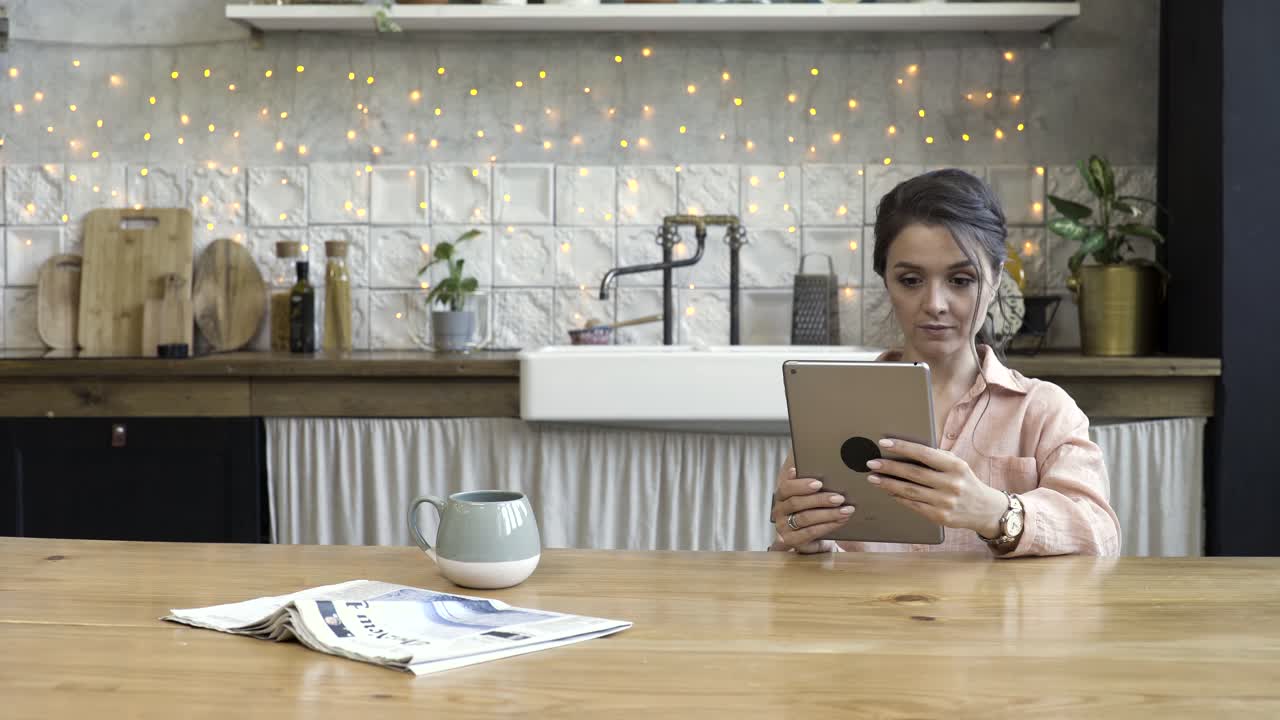 mujer usando tableta en la cocina