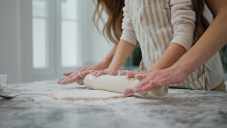 woman girl hands cooking dough at home. unrecognizable family flatten pastry