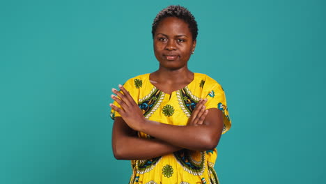 Portrait-of-cute-stylish-girl-smiling-and-holding-arms-crossed-in-studio