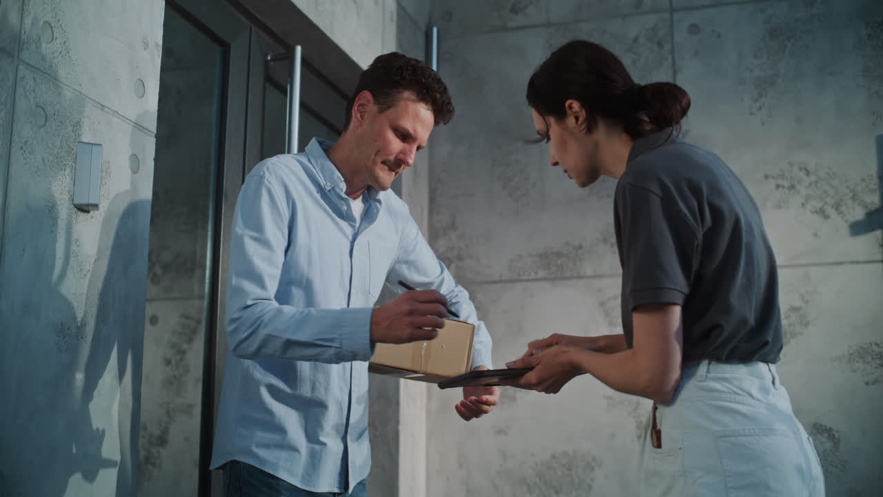 Man signing for a package delivery from a courier