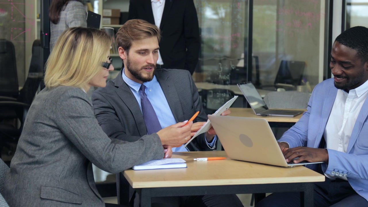 Professionisti aziendali di diversa provenienza che collaborano in una moderna riunione d'ufficio