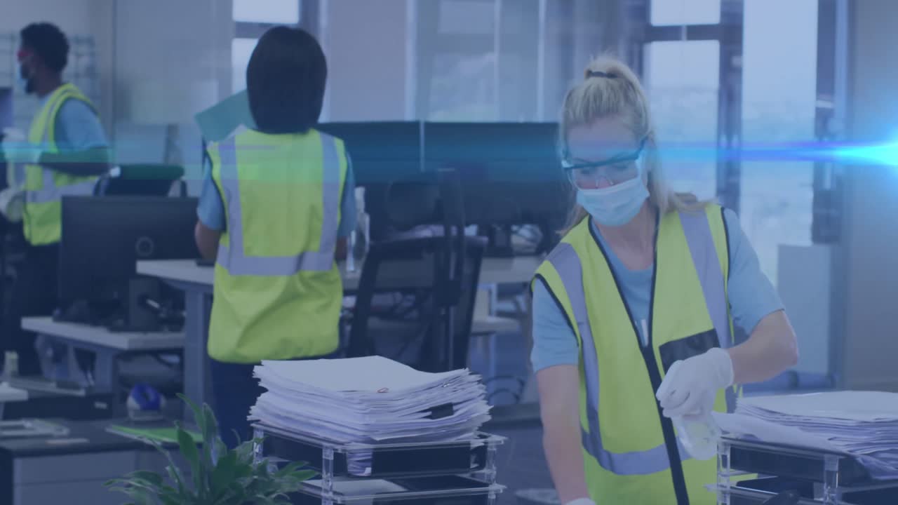 Animation of light spots over caucasian female worker with face mask disinfecting office