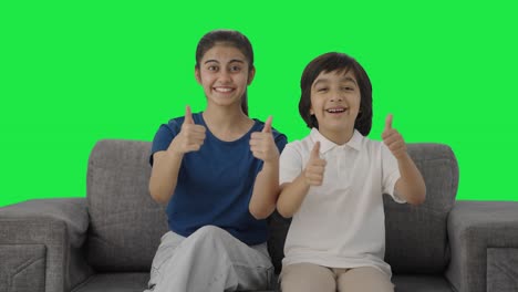 hermanos indios mostrando los pulgares hacia la cámara pantalla verde