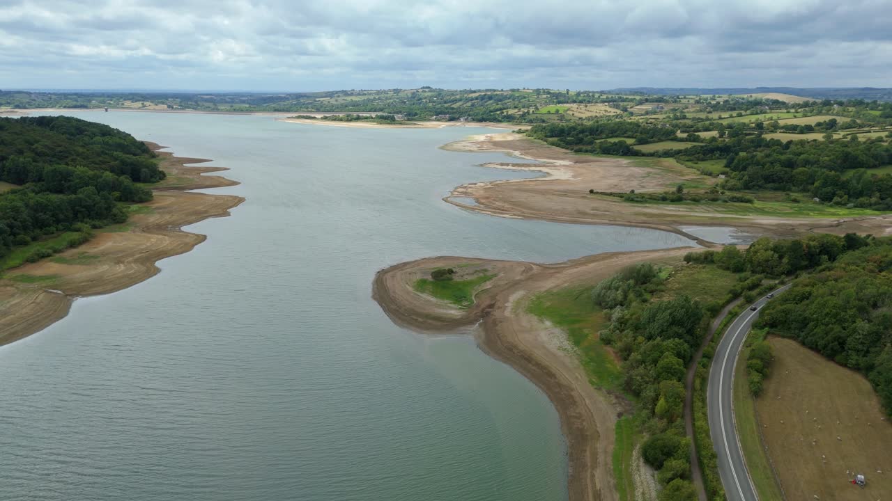 Scenic aerial drone view of Carsington Water reservoir with low water level and surrounding green landscape in Derbyshire Dales United Kingdom