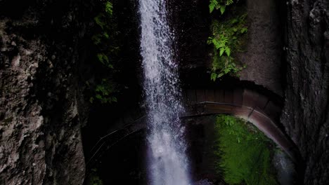 Aerial-view-of-a-small-waterfall-with-water-flowing-from-a-cliff