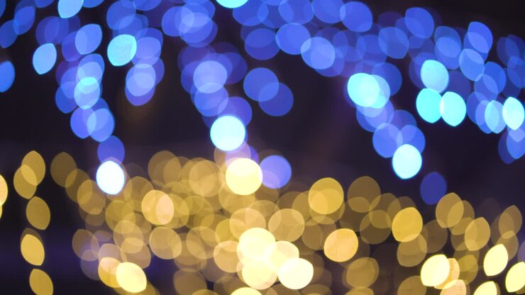 Cerchi bokeh blu e dorati di luci da festa che si muovono su sfondo nero