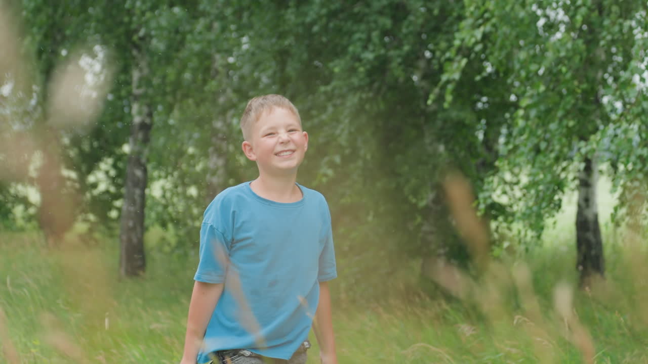 라켓을 휘두르며 웃고 있는 백인 소년, 셔틀콕의 움직임과 역동적인 팔로우스루, 초원 속 모션 블러, 활기찬 웃음, 야외의 자유로움, 시골 풍경, 근심 없는 젊음