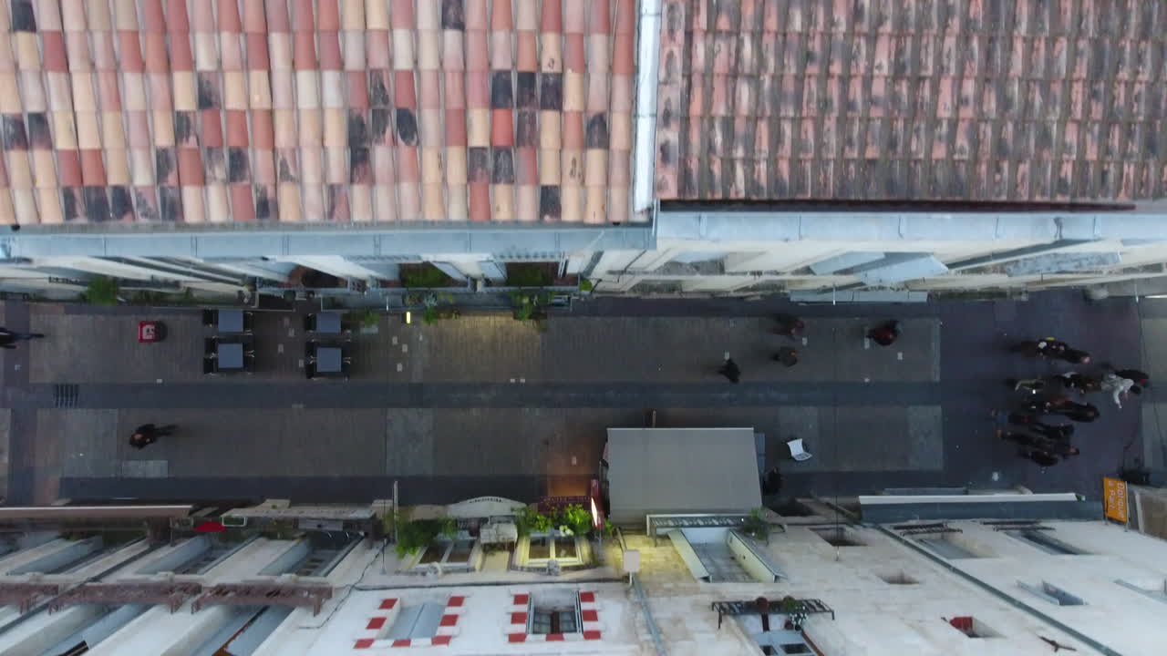 vista aérea lenta por encima de una calle entre dos edificios antiguos.