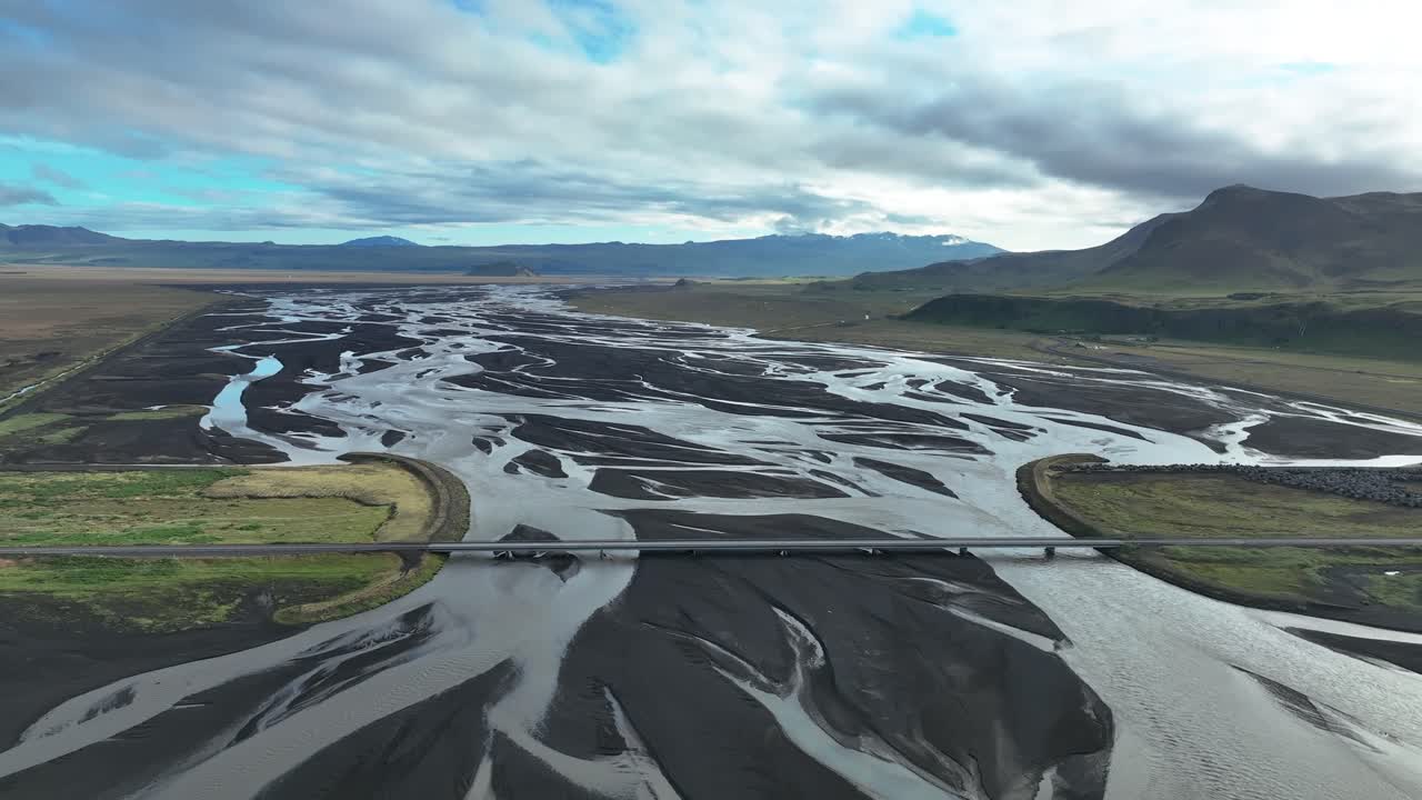 vista aérea panorámica de un puente sobre el lecho de un río glacial trenzado en el sur de islandia