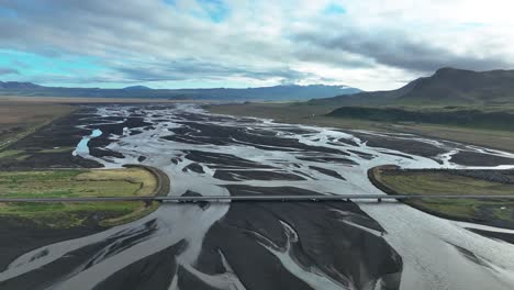 Panoramic-Aerial-View-Of-A-Bridge-Over-Braided-Glacial-Riverbed-In-Southern-Iceland