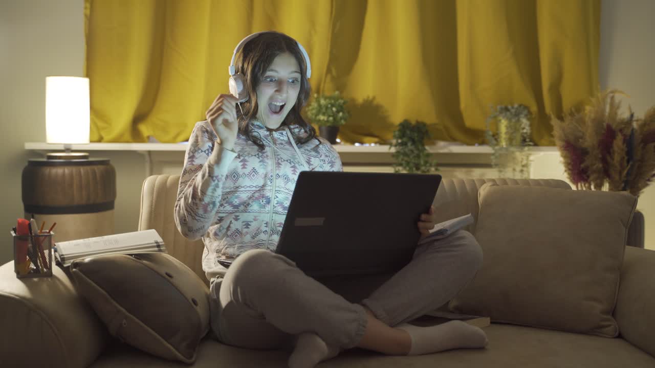 un estudiante varón que está feliz de que sus resultados de los exámenes son buenos. en casa por la noche.