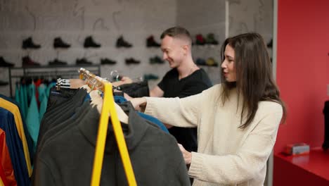 lovely couple shopping in mall choosing sportswear on the rack