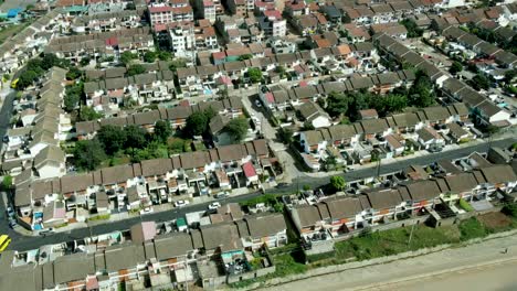 Descending-aerial-shot-of-african-intersection-with-driving-bus-and-Kibera-suburb-residential-area-behind