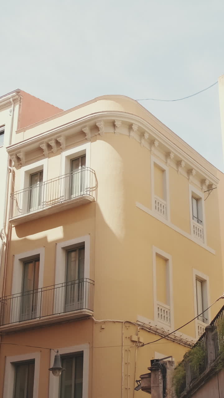 Fachada Clássica de Edifício Amarelo com Varandas e Poste de Luz