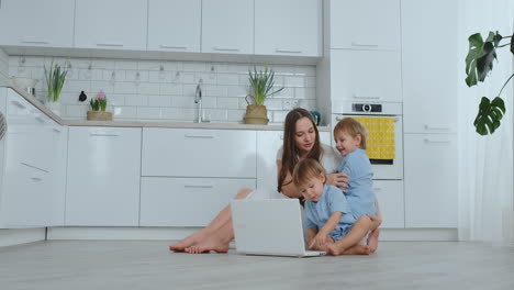 una joven madre progresista con dos hijos pequeños está hablando con su padre a través de la comunicación por video. la tecnología moderna es una familia joven.