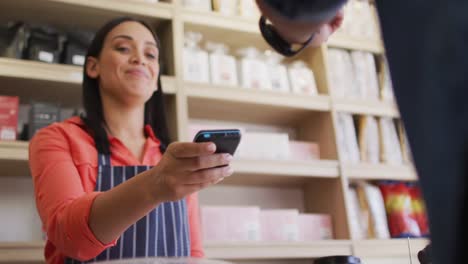 Video-of-hands-of-biracial-man-paying-with-smartphone-for-coffee