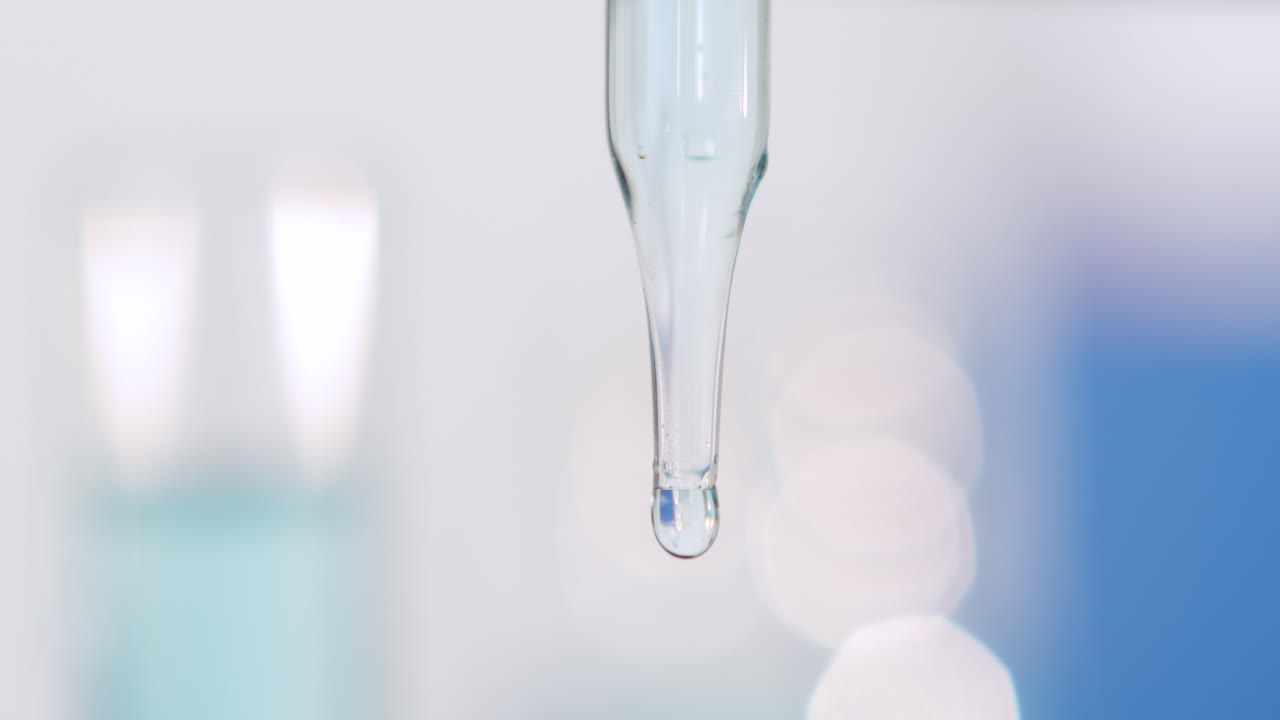 Pipette dropper with bubble and blurred bright background, cool fresh tones