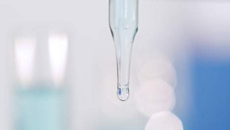 pipette dropper with bubble and blurred bright background, cool fresh tones