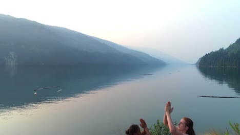 friends performing yoga near lakeside 4k