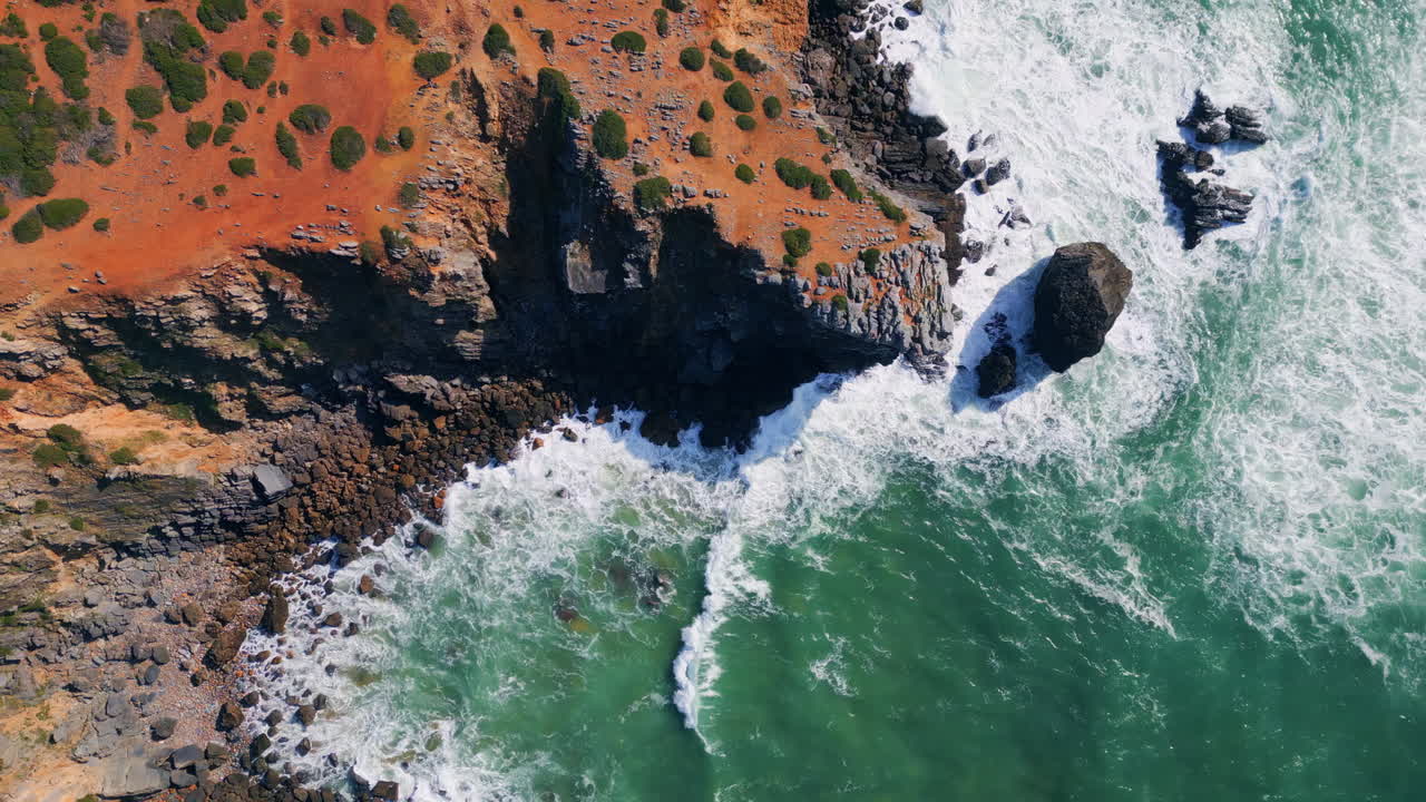 Cinematic scenic rocky shore over stormy foaming ocean. Drone marine landscape
