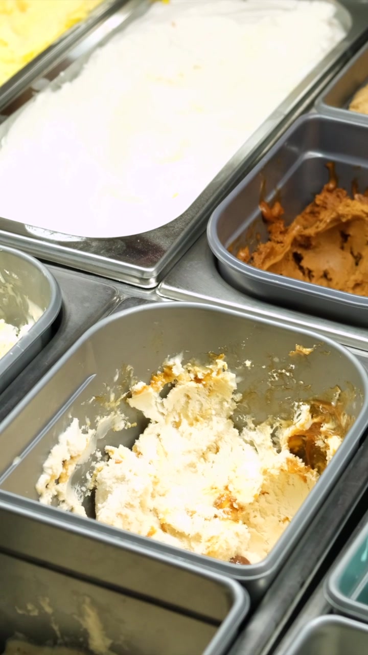 Primo piano di vari gusti di gelato in una gelateria